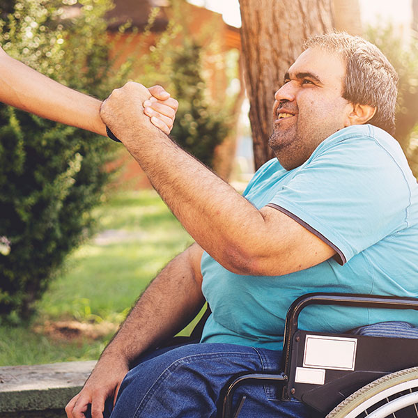 Man getting help out of a wheelchair