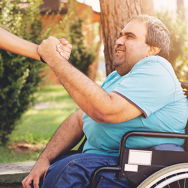 Man being helped out of a wheelchair