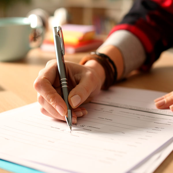 Close up of hand filling out a form